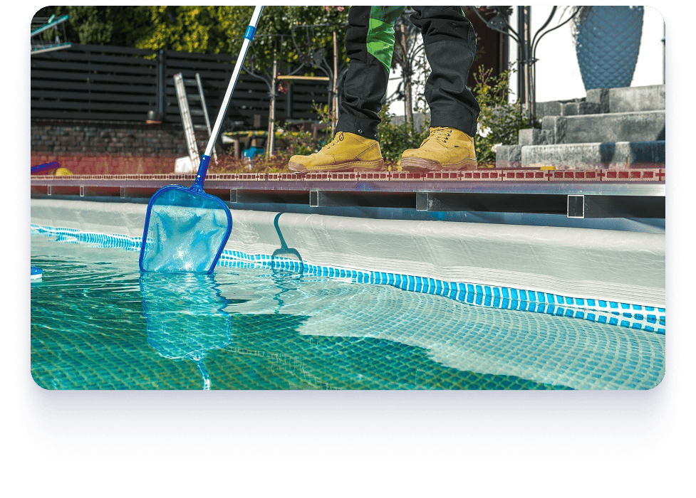 A man uses a mop to clean a commercial pool, highlighting the importance of professional pool services for businesses.