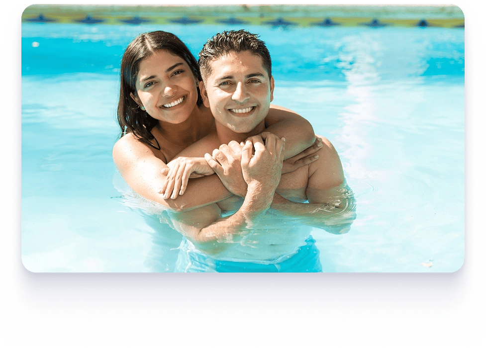 A man and woman relax in a swimming pool, showcasing flexible construction and financing for pool projects.