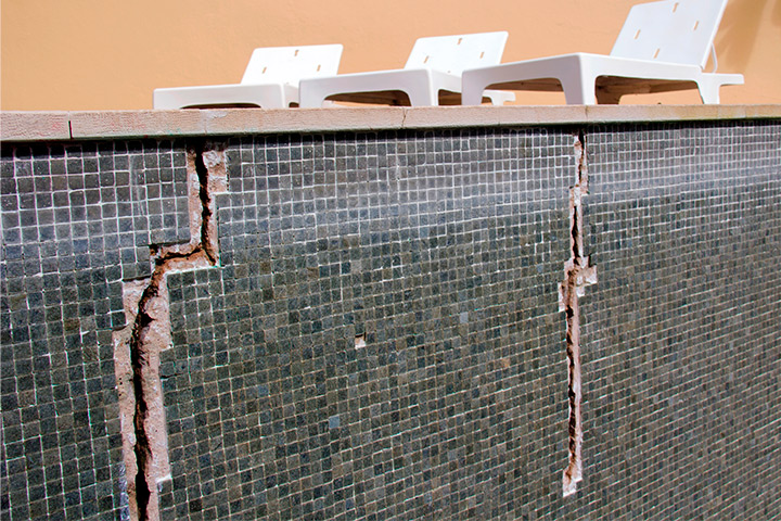 A broken pool with two chairs on its surface, highlighting the need for repair and maintenance attention.