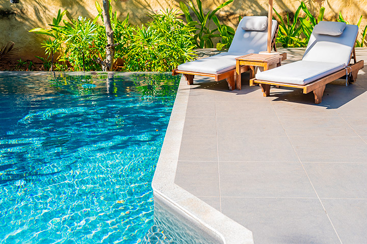 A tranquil pool with a lounge chair and umbrella, highlighting the craftsmanship of Right Pool Contractor in Austin.